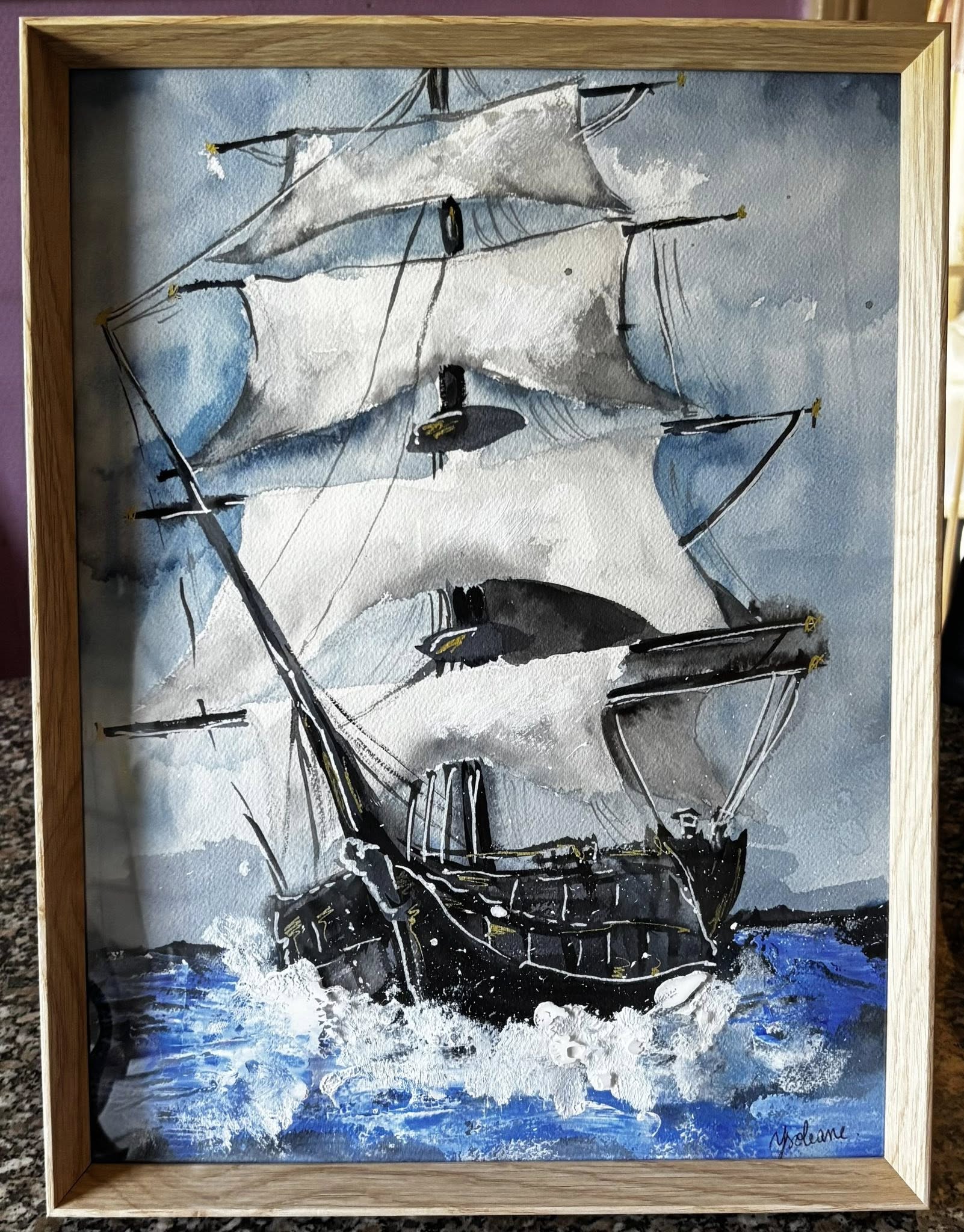 Aquarelle en noir, blanc et bleu — un galion à plusieurs mâts navigue sur une mer agitée, voiles déployées, présenté dans un cadre bois clair.