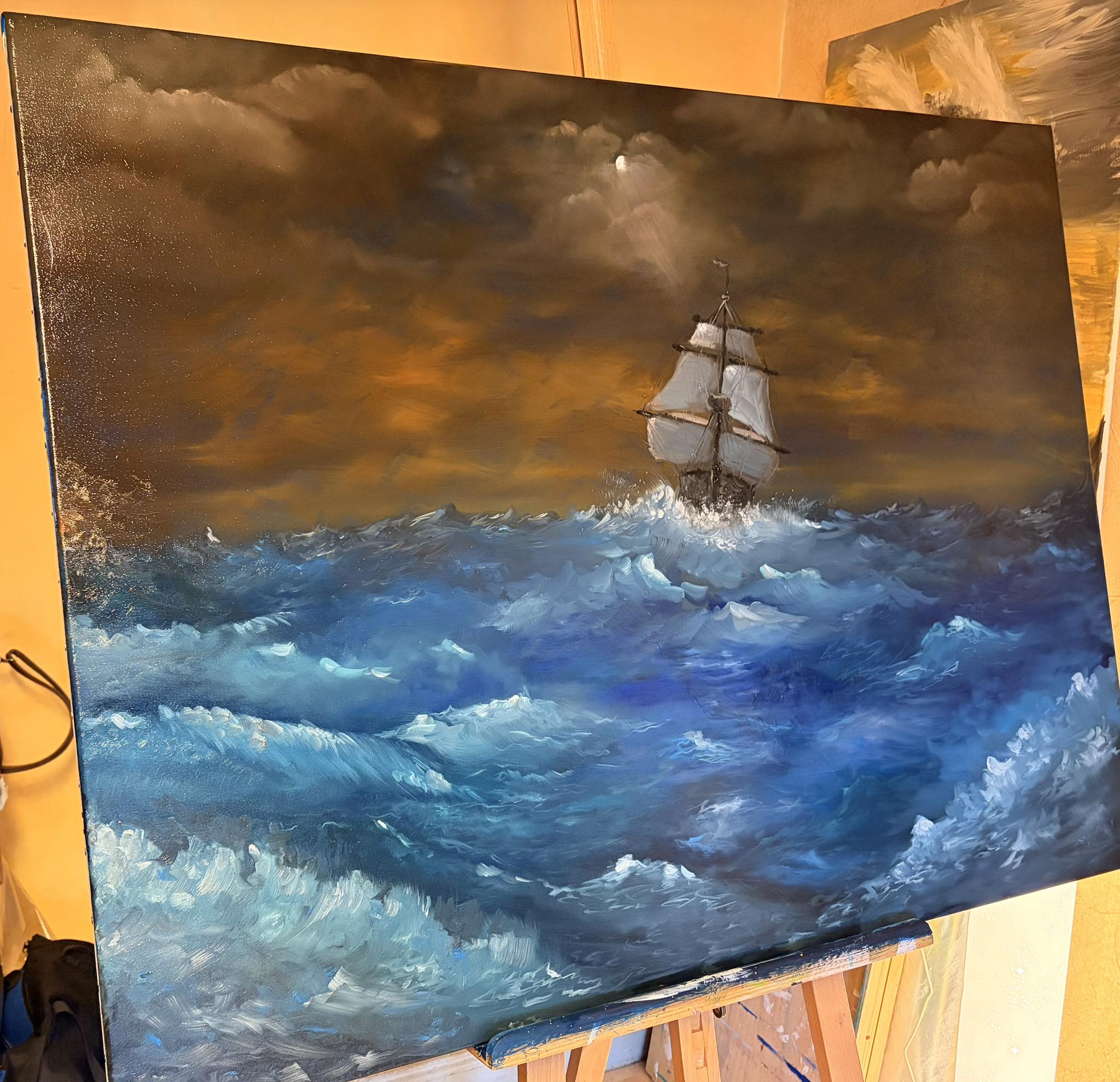 Huile sur toile — un trois-mâts file sur une mer écumante sous un ciel d'orage doré, lune voilée à travers les nuages.